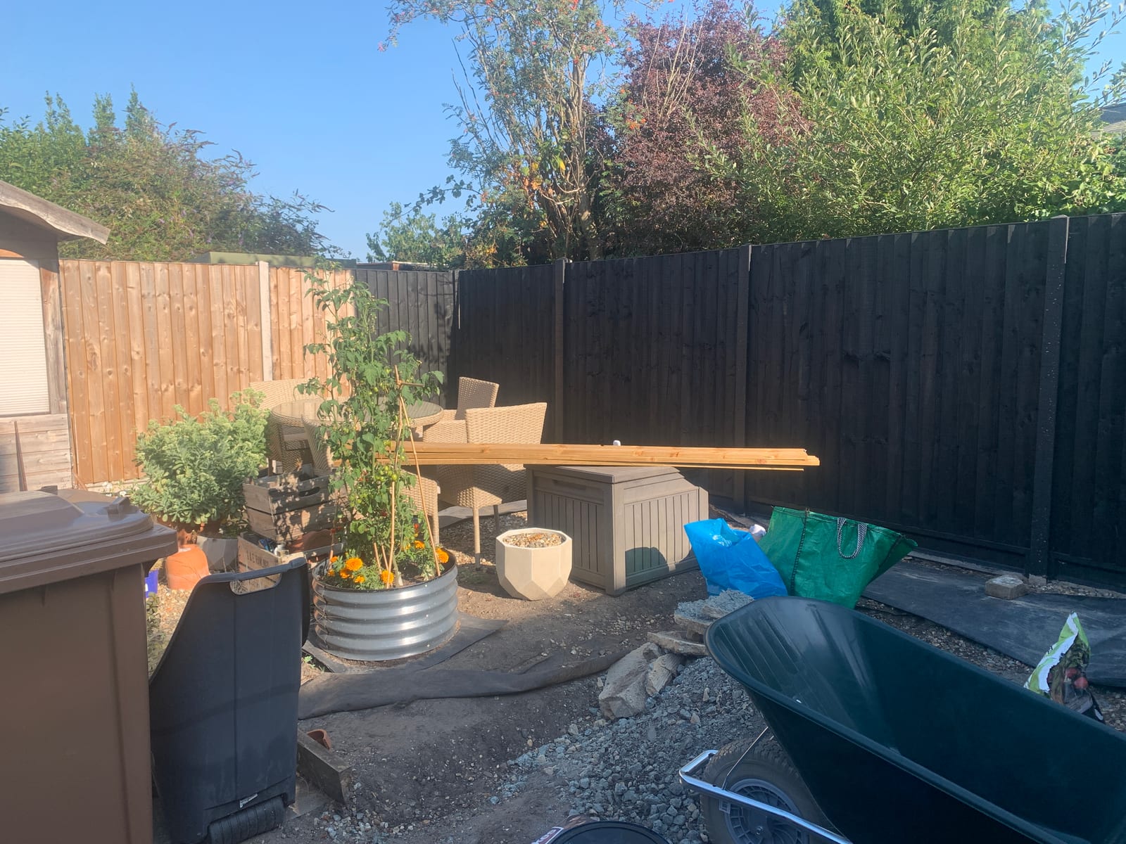 Garden fence in Saxmundham before and after painting from bare timber to black (after)