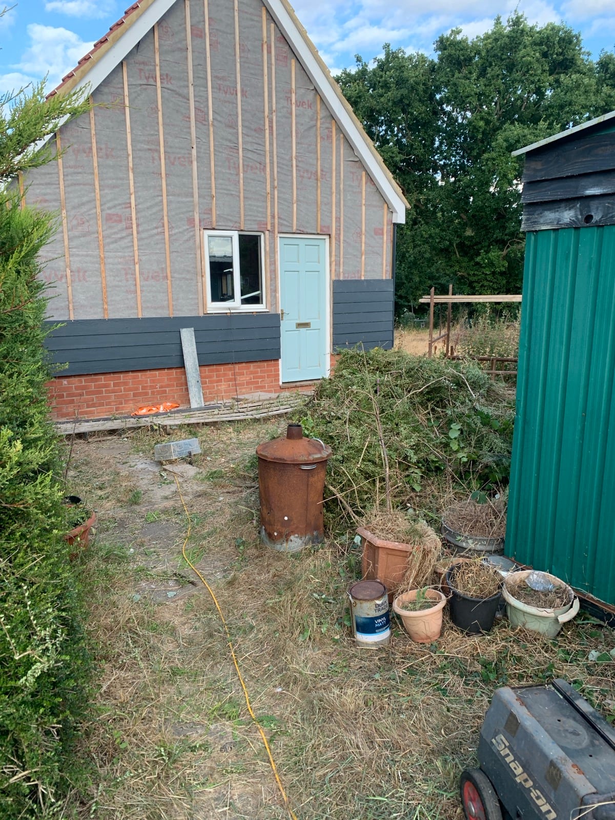 Overgrown back garden in Kelsale by the back door, before and after clearing (after)